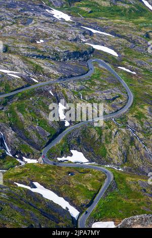 Paesaggio verde con macchie di neve e una strada tortuosa vista in Norvegia Foto Stock