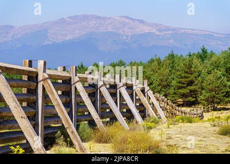 Recinzione in legno contro il forte vento che scende dalla cima della montagna nella Comunità di Madrid, Spagna Foto Stock