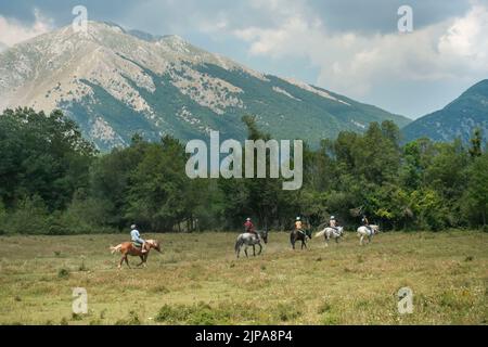 Abruzzo, Italia - 2022 agosto : persone a cavallo in una soleggiata giornata estiva nella regione alpina Appennini Foto Stock