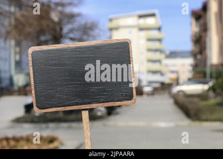 Etichetta lavagna e un edificio di appartamenti sullo sfondo, spazio copia. Foto Stock