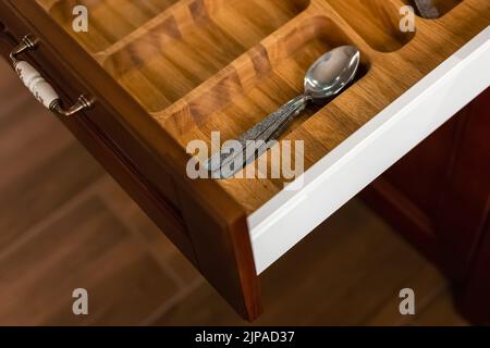 Cucina moderna. Set di posate nel cassetto della cucina. Inserti per cassetti di posate in legno massello di quercia. Foto Stock