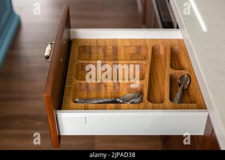 Cucina moderna. Set di posate nel cassetto della cucina. Inserti per cassetti di posate in legno massello di quercia. Foto Stock