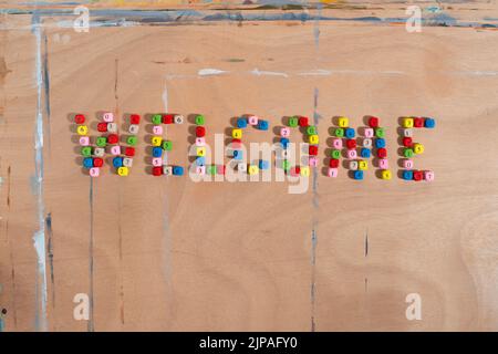 Parola di benvenuto fatta di palline colorate di numero su sfondo di legno. Concetto di ritorno a scuola. Foto Stock