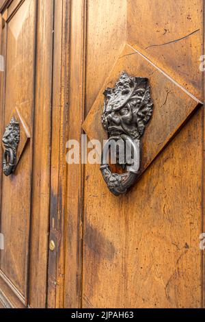 Vecchie porte di legno con anelli e vecchio stile in acciaio annata knoccer maniglia da vicino. Foto Stock