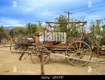Attrezzature per i minatori antichi, il Ranch presso l'Oasis Hotel, Furnace Creek, piscina e alberi di palma nel deserto Death Valley National Park, California, Foto Stock