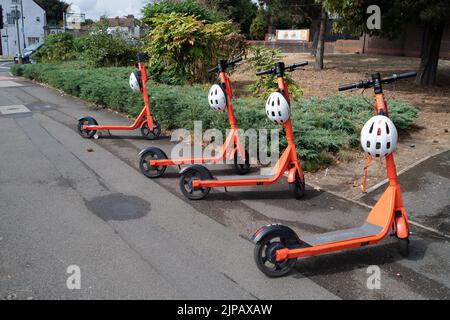 Slough, Regno Unito. 16th agosto, 2022. Il programma di noleggio di prova e-Scooters a Slough gestito dalla società Neuron Mobility, è stato prorogato per altri due anni. Gli scooter arancioni sono popolari, tuttavia, gli scooter elettronici in generale sono stati criticati in quanto alcuni utenti velocità sui marciapiedi e le strade con loro causando incidenti. Alcuni utenti sono stati anche segnalati per essere sotto l'influenza di alcol quando li usa, in particolare di notte. Credit: Maureen McLean/Alamy Live News Foto Stock