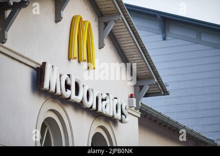 Un primo piano di un cartello McDonald's su un edificio bianco Foto Stock
