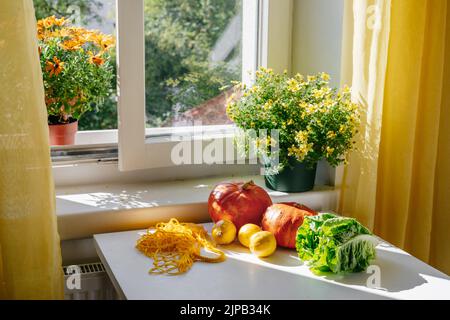 NET bag con verdure e frutta - Punpkin, insalata verde - sul tavolo da cucina di fronte alla finestra. Fermo vita. ero rifiuti e plastica senza concetto. Acquista cibo biologico locale Foto Stock