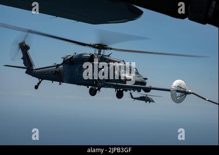 Un elicottero HH-60G Pave Hawk viene rifornito da un 39th Rescue Squadron HC-130J Combat King II durante una gara di tiro al tacchino al largo della costa della Florida il 16 giugno 2022. Durante il concorso, i membri dell'equipaggio hanno gareggiato su abilità come l'impiego di armi da aerei, il rifornimento di aerei da elicotteri, la navigazione degradata, la ricerca degradata e il sollevamento confinato. (STATI UNITI Foto forza spaziale di Senior Airman Thomas Sjoberg) Foto Stock