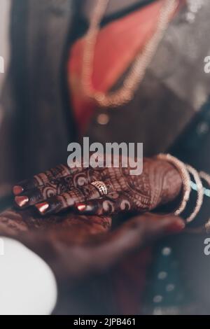 Un colpo verticale di una sposa indù e sposo mano in mano alla cerimonia Foto Stock
