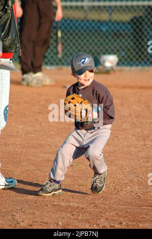 Giovani e allenatori su campi sportivi durante gli sport primaverili, allenati e giocati, partite di baseball Foto Stock