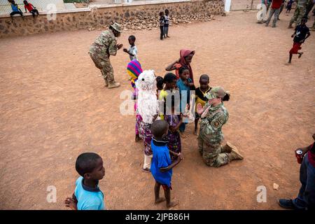 15 luglio 2022 - Chabelley Village, Gibuti - U.S. Air Force Tech. SGT Rica Jackson, 776th base aerea Expeditionary Squadron NCO responsabile degli impianti elettrici, in alto a sinistra, e Tech. SGT Kelsey Loeser, 776th EABS Command Executive, in basso a destra, gioca una partita di rima con i bambini durante una visita al villaggio di Chabelley, Gibuti, 15 luglio 2022. Attraverso importanti impegni di leadership e visite in loco, gli Airmen del 449th Air Expeditionary Group cercano il feedback dai villaggi locali, dagli anziani e dai funzionari regionali per creare fiducia e rafforzare le partnership. (Credit Image: © U.S. Air Force/ZUMA Press Wire S Foto Stock