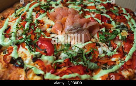 Pizza al salmone affumicato. Pizza tradizionale italiana con salmone affumicato su tavolo di legno. Nessuno, sfocato, fuoco selettivo Foto Stock