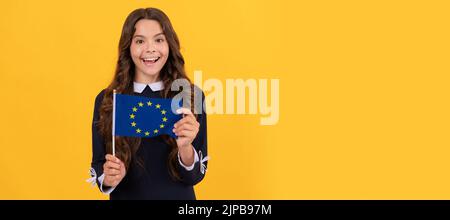 capretto stupito tenere bandiera unione europea sfondo giallo, unione europea. Poster orizzontale di lato bambino isolato, intestazione banner, spazio di copia. Foto Stock