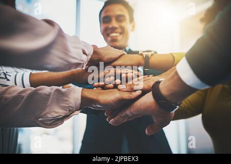 Motivato più che mai. Primo piano di un gruppo irriconoscibile di uomini d'affari che uniscono le mani in una barzelletta. Foto Stock