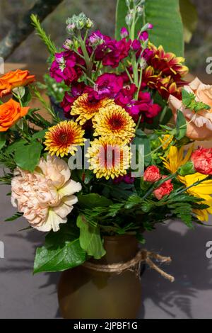 Vista ravvicinata di un bouquet di fiori colorati e luminosi in una sistemazione fiorista al coperto Foto Stock