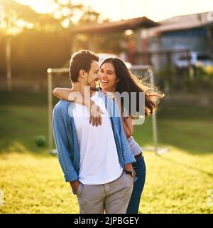 Si può solo dire che theyre felice nell'amore. Una giovane coppia affettuosa che si unisce insieme all'aperto. Foto Stock