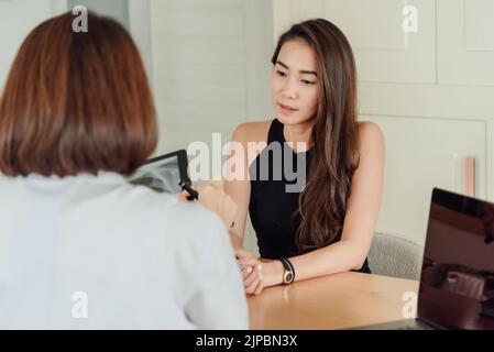 Una paziente di sesso femminile sta ascoltando il medico spiegare dopo una radiografia. Foto Stock