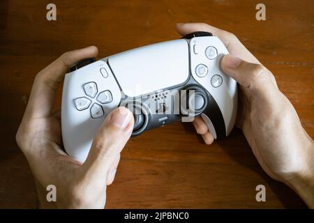 Bangkok, Thailandia - 28 luglio 2022: Giocatore che gioca alla console di gioco PlayStation 5 con il controller DualSense. Foto Stock
