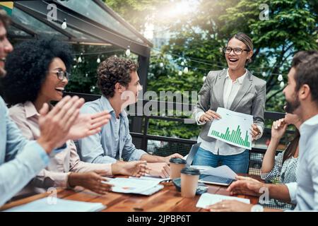 Concludere la riunione con una nota positiva: Un gruppo di colleghi applaude durante una riunione in un bar. Foto Stock