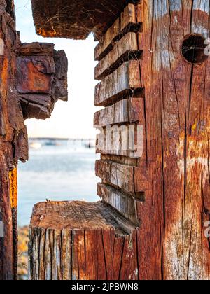 Un groyne di legno testurizzato con segni tagliati e una vista sul mare dietro Foto Stock