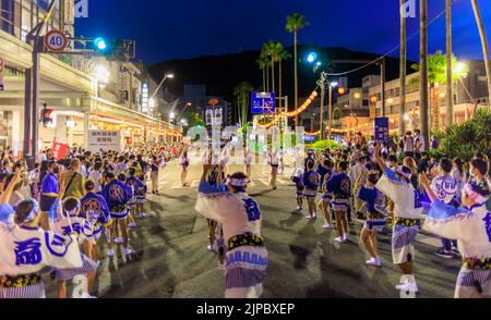 Gli artisti ballano in strada mentre la notte cade in un tradizionale festival giapponese Foto Stock