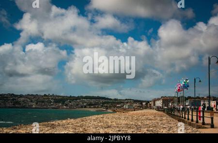 Bandiere lungo la passeggiata Penzance con Newlyn in lontananza sul Quay Fair Day, Golowan, spazio per la copia Foto Stock