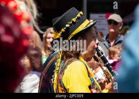 Un clarinetista processi dopo la folla per il giorno Mazey Golowan a Penzance, Cornovaglia Foto Stock