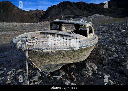 10 maggio 2022 - Lake Mead National Recreation Area, Nevada, Stati Uniti - Una barca in precedenza affondata ora riposa su terra asciutta lungo il lago Mead, colpito dalla siccità, presso la Lake Mead National Recreation Area. Il Bureau of Reclamation degli Stati Uniti ha riferito che il lago Mead, il più grande bacino artificiale del Nord America, è sceso a circa 1.052 metri sopra il livello del mare, il più basso è stato da quando è stato riempito nel 1937 dopo la costruzione della diga di Hoover. Due serie di resti umani sono stati scoperti recentemente mentre il lago continua a recedere. (Credit Image: © David Becker/ZUMA Press Wire) Foto Stock