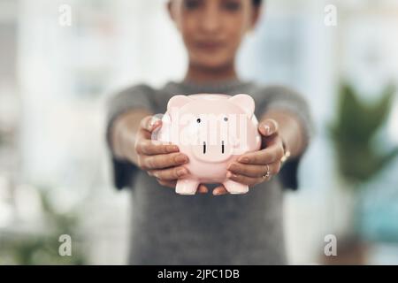 Piggybank, finanza e denaro nelle mani di una donna con una mentalità sul futuro del risparmio, degli investimenti e della ricchezza. Primo piano di una banca di monete in mano Foto Stock