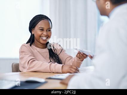 Paziente che riceve script medico, prescrizione medica e nota di malattia da un medico durante una consultazione, controllo e visita in un ospedale o clinica. Donna sorridente Foto Stock