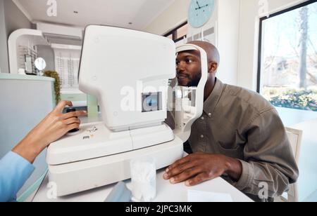 Esame oculare, esame o screening con un giovane uomo all'optometrista utilizzando un rifrattore automatico. Paziente che prova la sua visione e la vista con un ottico Foto Stock