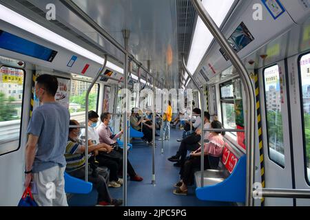 All'interno di un treno, i passeggeri sulla linea 3 della metropolitana di Shenzhen indossano maschere facciali dopo il primo blocco. Foto Stock