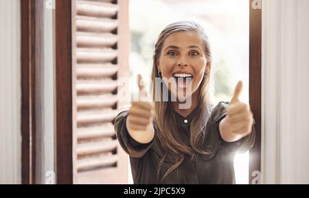 Pollici in su, donna eccitato e allegra che mostra segno positivo della mano dopo avere ottenuto le buone notizie e l'approvazione dell'occasione di lavoro. Femmina con un positivo Foto Stock