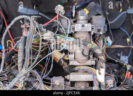 Un fascio di cavi o fili elettrici è fortemente mescolato l'uno con l'altro. Resti di fili di colori diversi. Cavi vecchi collegati l'uno all'altro Foto Stock