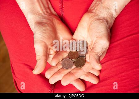 Le mani delle donne tengono in ginocchio monete ruble, default e povertà del popolo russo a causa della guerra in Ucraina Foto Stock