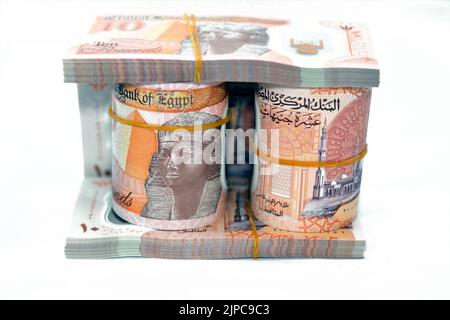 Egitto rotoli di denaro e pile di nuove prima egiziana 10 LE EGP dieci libbre polimero di plastica banconota isolato su sfondo bianco, egiziano sterline cash mo Foto Stock