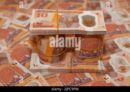 Egitto rotoli di denaro e pile di nuove prima egiziana 10 LE EGP dieci libbre polimero di plastica banconota su un mucchio di nuovi soldi egiziani, sterline egiziane contanti Foto Stock
