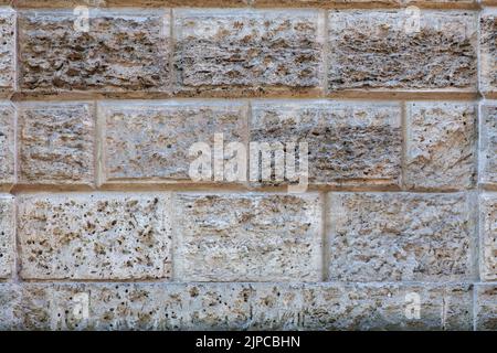Immagine di sfondo - un frammento della parete di un antico edificio fatto di rocce vulcaniche. Foto Stock