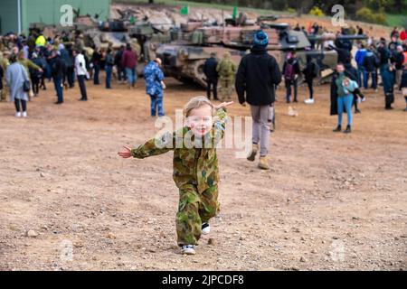 Puckapunyal, Australia, 17 agosto 2022. Il giovane Maddie di Puckapunyal controlla che cosa il suo papà fa nella sua propria uniforme dell'esercito durante una dimostrazione della potenza di fuoco dell'esercito per gli ospiti e le famiglie una gamma Puckapunyal a Victoria. Credit: Michael Currie/Speed Media/Alamy Live News Foto Stock