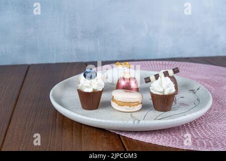 Dolci sofisticati per matrimoni brasiliani. Macaron, tartufi e piccole tazze di cioccolato vista laterale. Foto Stock