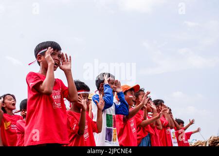 Giacarta nord, Indonesia. 18th ago, 2022. I bambini fanno canti durante la cerimonia di celebrazione del giorno dell'Indipendenza Indonesiana. I bambini di "Kelas Jurnalis Cilik" celebrano la giornata dell'indipendenza dell'Indonesia attraverso la cerimonia di sollevamento della bandiera a Cilincing, nel nord di Giacarta. Credit: SOPA Images Limited/Alamy Live News Foto Stock