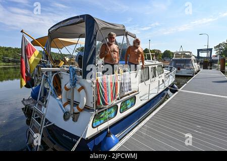 17 agosto 2022, Brandeburgo, Kersdorf: Peter Fischer (l) e Matthias Graupner, amici e pensionati, aspettano su una barca sulla Sprea di fronte alla chiusa serratura di Kersdorf per l'ingresso al canale Oder-Spree. Il pescatore di 74 anni e il suo amico di 69 anni Graupner stanno aspettando con le loro due barche di fronte alla chiusa serratura di Kersdorf dall'agosto 11. La serratura collega il Fürstenwalde Spree con il canale Oder-Spree e poi a Eisenhüttenstadt con il fiume di confine tedesco-polacco Oder. Per evitare possibili contaminazioni con l'acqua proveniente dal fiume Oder e dal fiume Sprea, tutte le chiuse sono chiuse Foto Stock