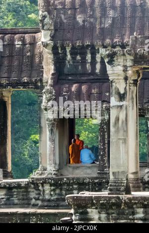 I monaci buddisti riposano all'ombra: Ingresso alla galleria est, Angkor Wat, Siem Reap, Cambogia Foto Stock