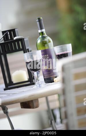 Bicchieri di vino rosso su un tavolo con bottiglia e pane Foto Stock