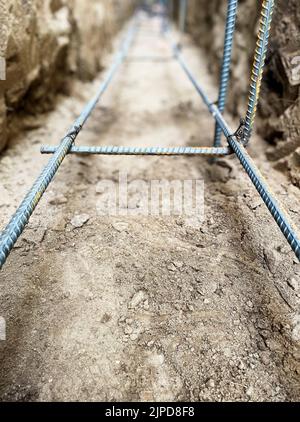 Barre di ancoraggio in acciaio da costruzione nel telaio di base per trincea Foto Stock