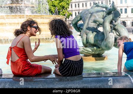 I giovani si raffreddano nelle fontane di Trafalgar Square durante il giorno più caldo mai registrato nella capitale, Londra, Regno Unito. Foto Stock