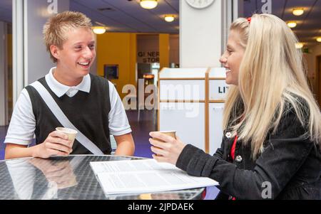 Studenti adolescenti, pausa caffè. Gli amici della scuola chiacchierano sopra il caffè nel loro refettorio dell'università. Da una serie di immagini correlate. Foto Stock