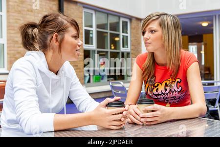 Studenti adolescenti, migliori amici. Gli amici della scuola che condividono un momento sopra il caffè nel loro refettorio dell'università. Da una serie di immagini correlate. Foto Stock