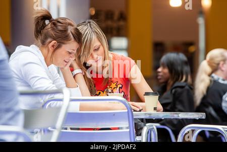 Studenti adolescenti, conversazione candida. Gli amici della scuola si rilassano sopra il caffè nel loro refettorio dell'università. Da una serie di immagini correlate. Foto Stock